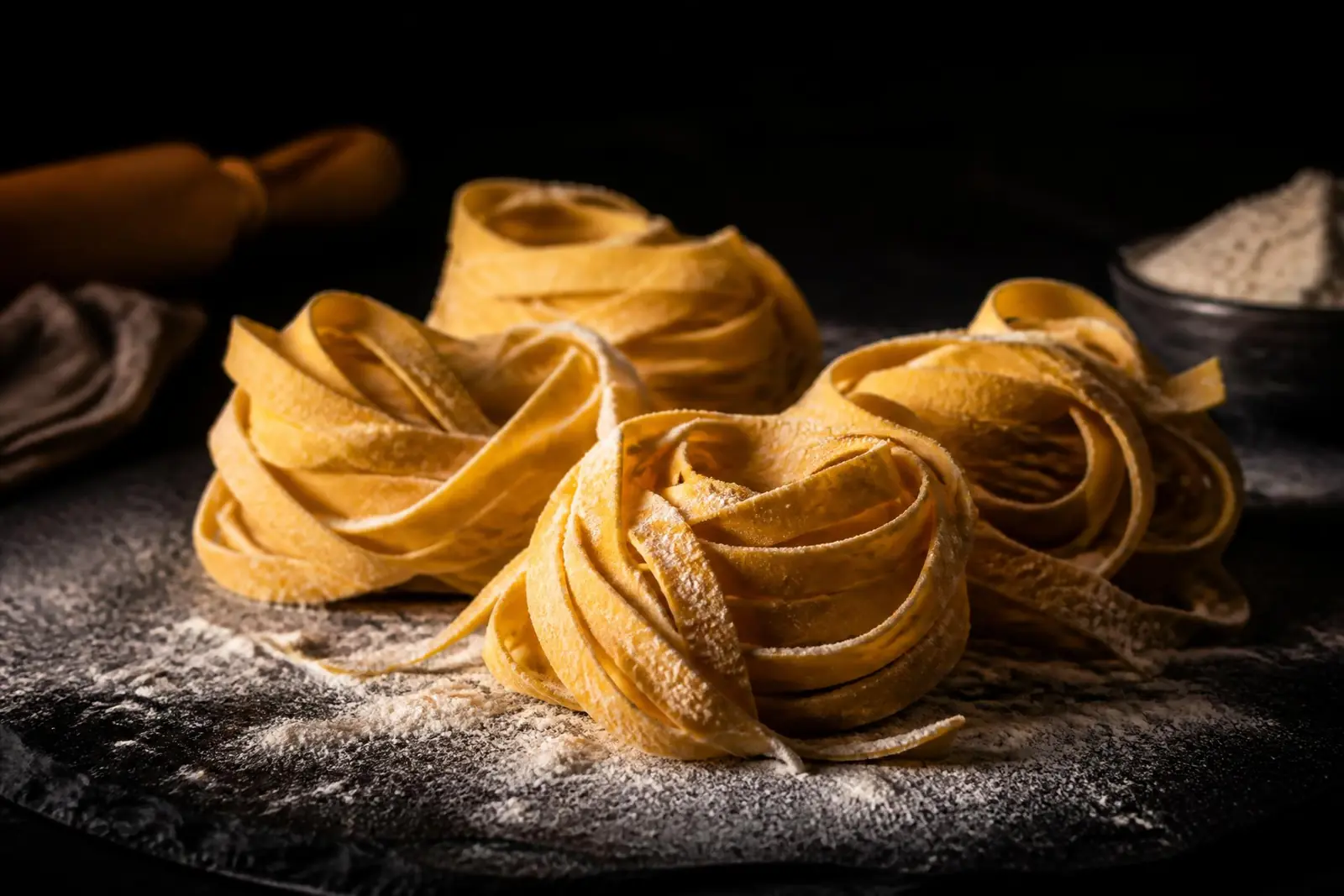 Nids de tagliatelle artisanales Casa Ceppini sur un plan sombre fariné
